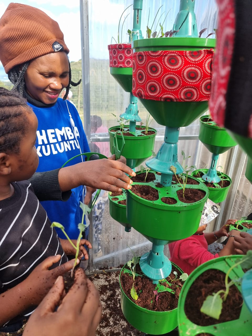 Children planting with their teacher
