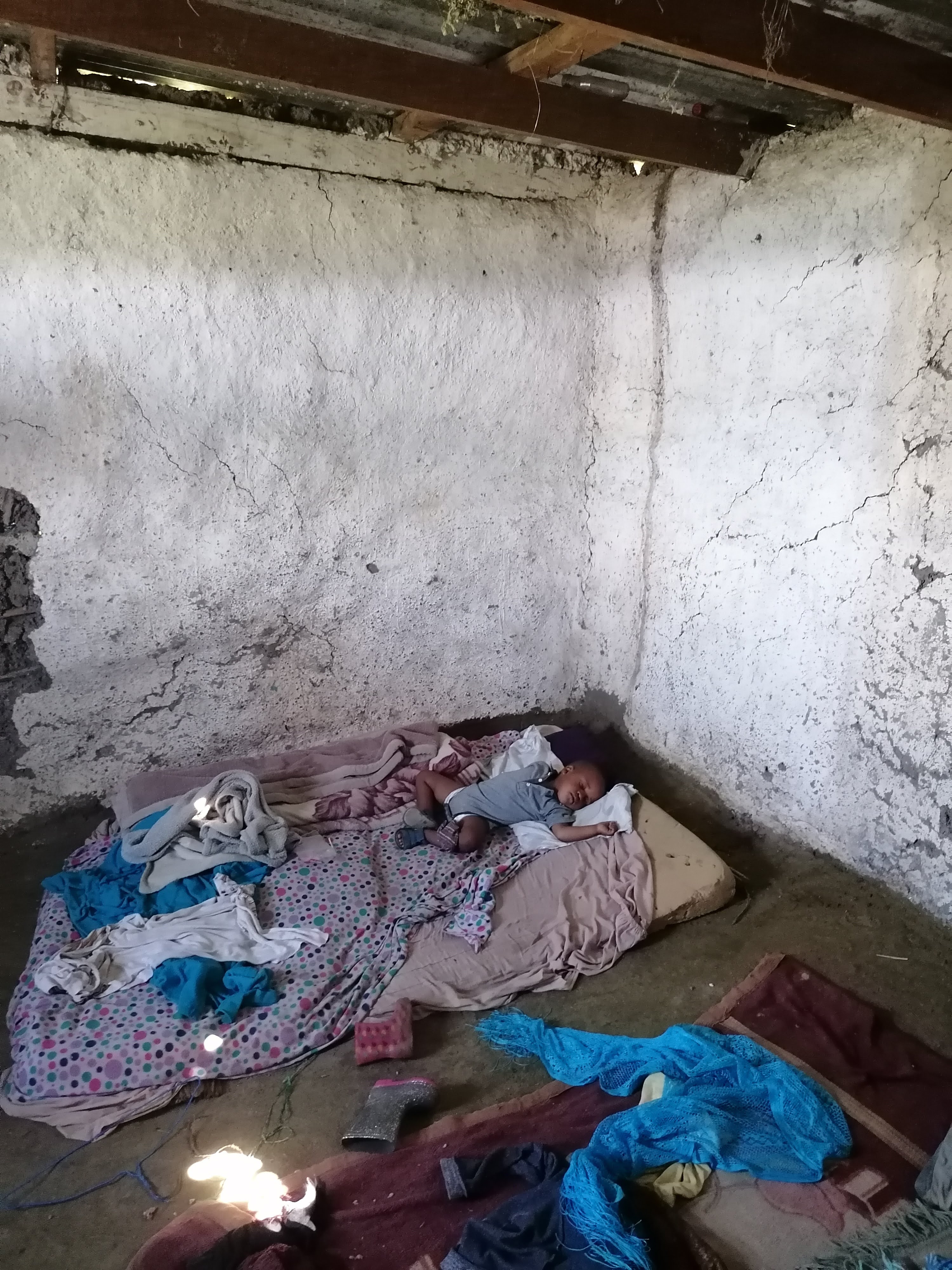 Bare room with bedding on the floor after hardship