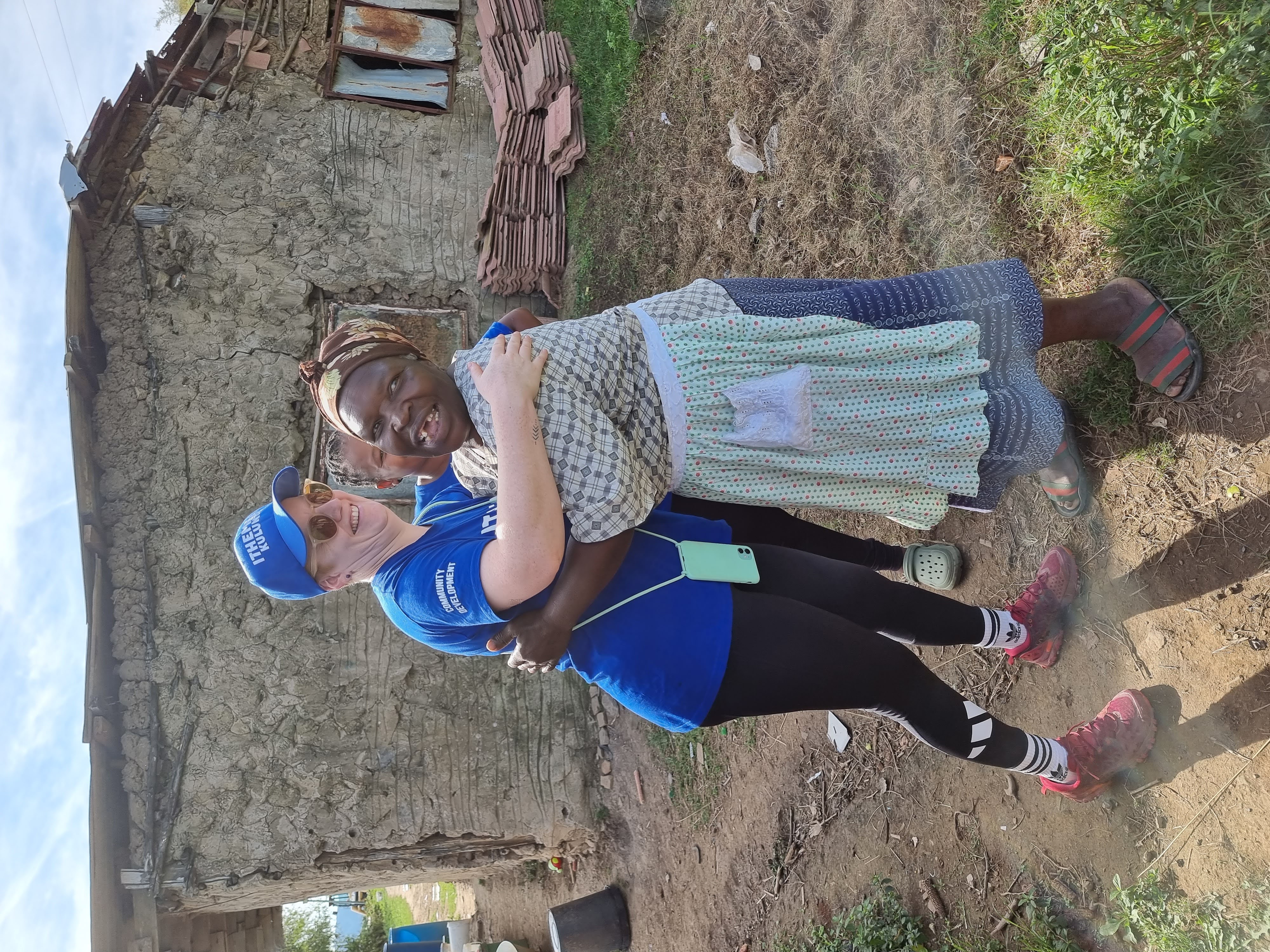 Community worker embracing a child during a home visit