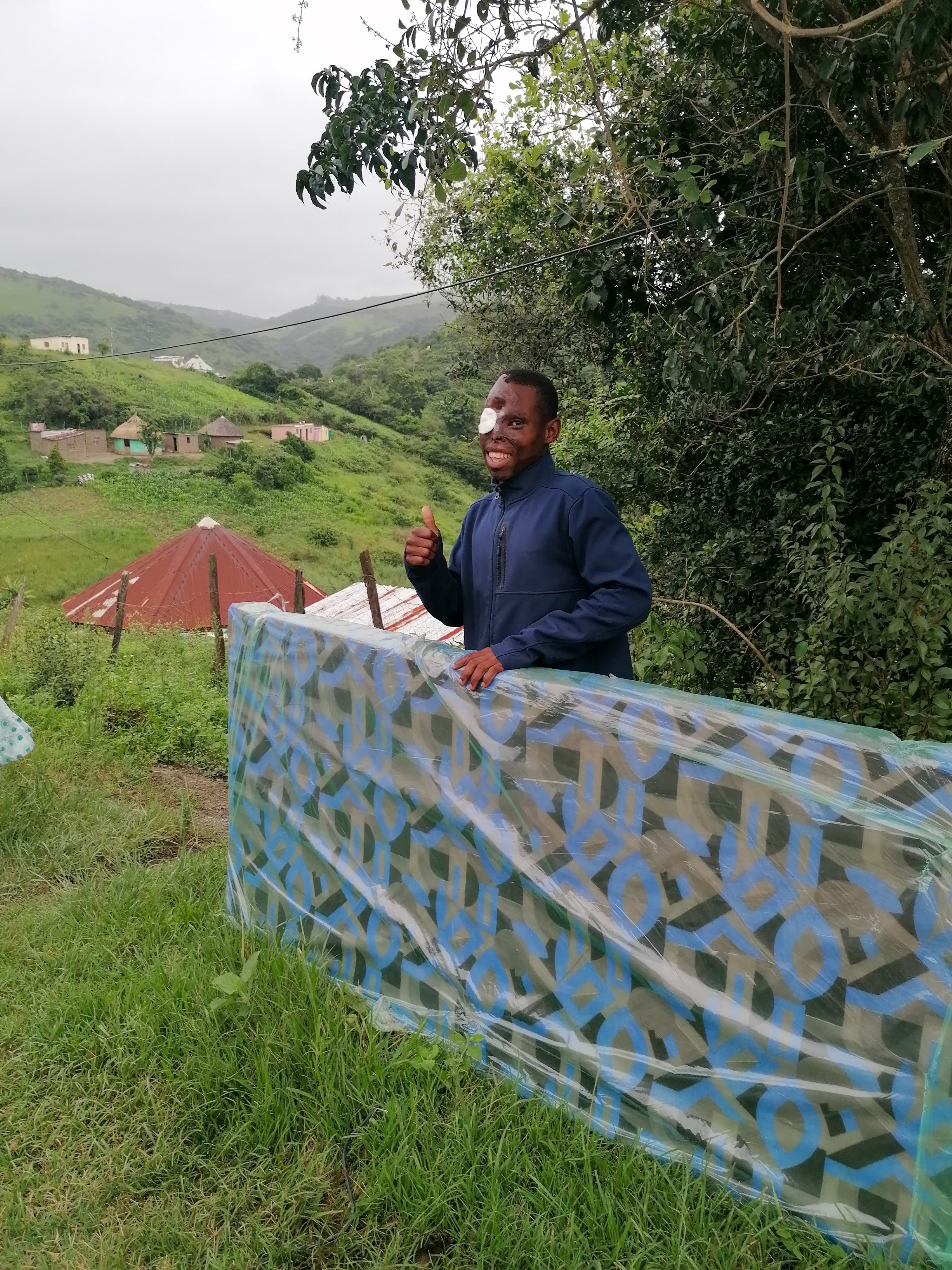 Woman carrying a new mattress through the village