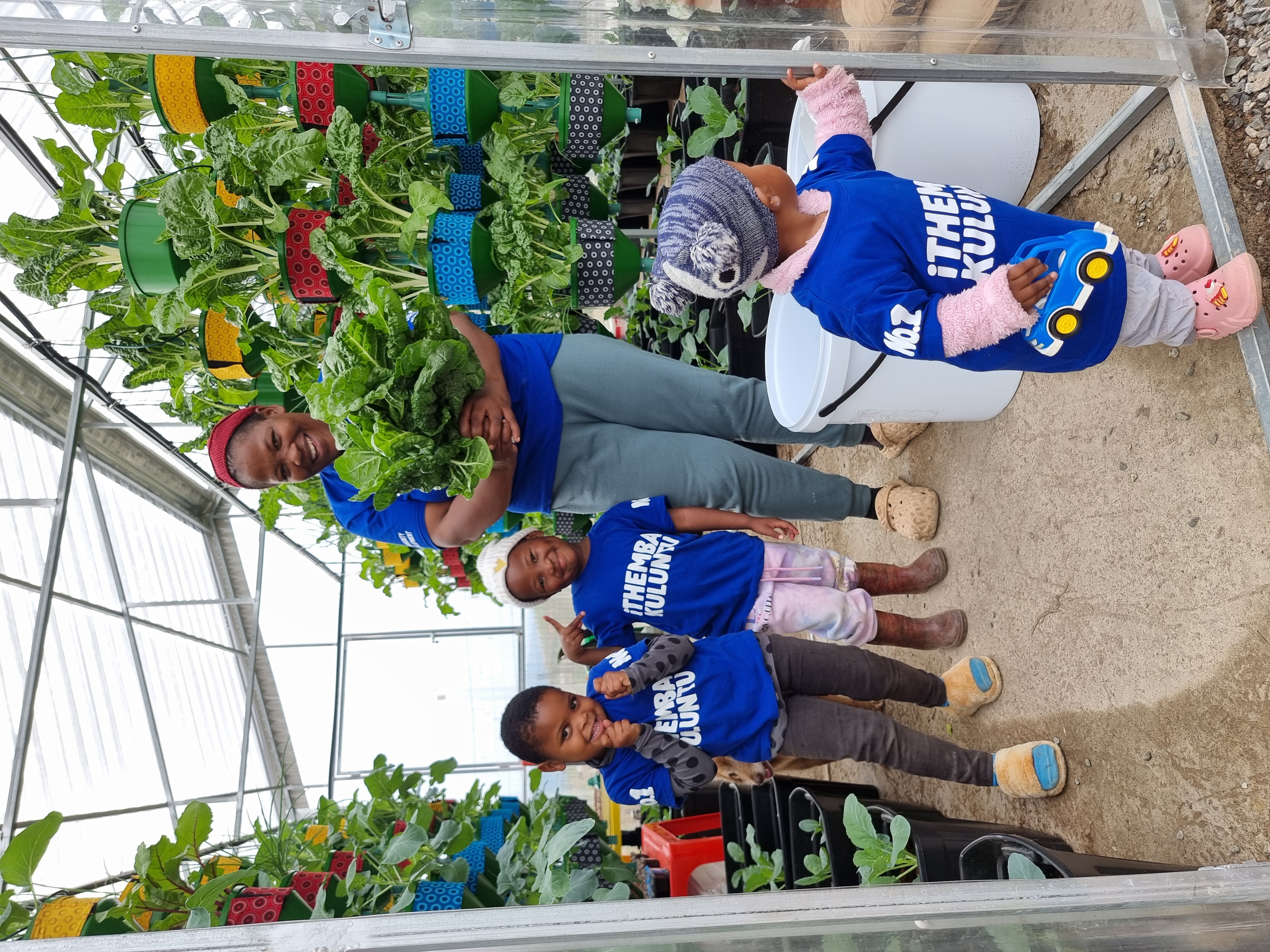 Community group celebrating a greenhouse harvest