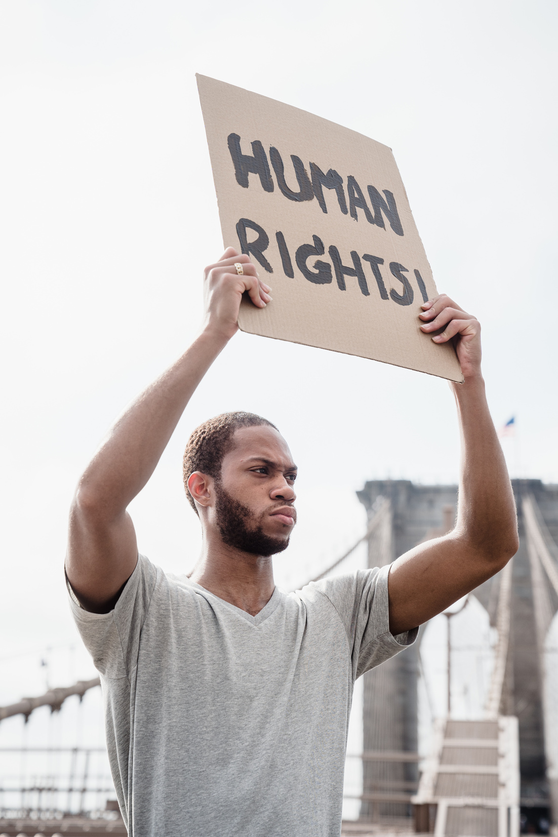 Photo of a Man Raising a Human Rights Signage
